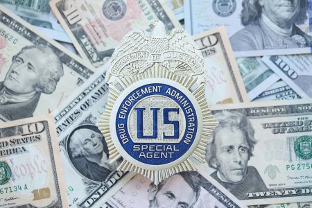 Foto de KYIV, UCRANIA - 9 de marzo de 2024 DEA-EE.UU. La insignia de agente especial en muchos billetes de dólar estadounidense se cierra - Imagen libre de derechos