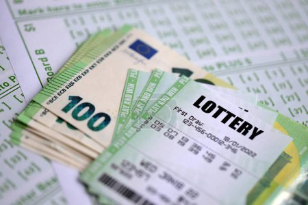 Billetes de lotería verde y billetes de dinero en euros en blanco con números para jugar a la lotería de cerca