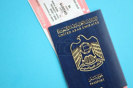 Reisepass der Vereinigten Arabischen Emirate mit Flugtickets auf blauem Hintergrund in Großaufnahme. Tourismus- und Reisekonzept