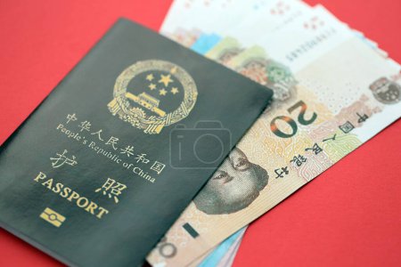 Pasaporte rojo de la República Popular China y billetes de yuan chino. pasaporte chino de la República Popular China sobre fondo brillante de cerca