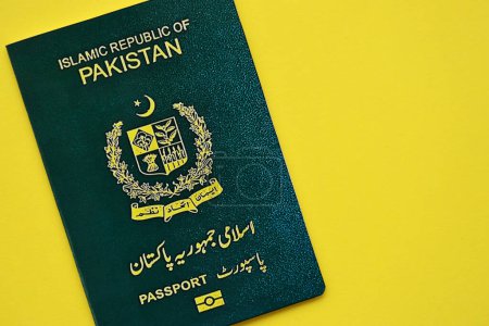 Pasaporte de la República Islámica Verde de Pakistán sobre fondo amarillo de cerca. Concepto de turismo y ciudadanía