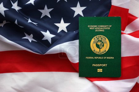 Grüner nigerianischer Pass auf dem Hintergrund der US-Nationalflagge in Großaufnahme. Tourismus- und Diplomatie-Konzept