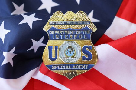 Foto de KYIV, UCRANIA - 9 de marzo de 2024 US Interpol Special Agent badge on United States of America flag close up - Imagen libre de derechos