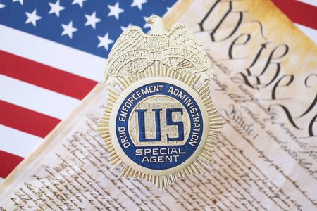 Téléchargez les photos : KYIV, UKRAINE - 9 MARS 2024 US DEA Insigne d'agent spécial avec la Constitution des États-Unis près du drapeau - en image libre de droit