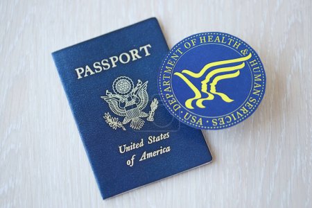 Foto de KYIV, UCRANIA - 9 de marzo de 2024 Departamento de Salud de los Estados Unidos y sello de servicios humanos y pasaporte de los Estados Unidos en la mesa de madera - Imagen libre de derechos