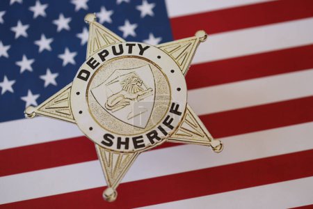 Foto de KYIV, UCRANIA - 9 de marzo de 2024 Insignia del Sheriff Adjunto de los Estados Unidos en la bandera de los Estados Unidos de América de cerca - Imagen libre de derechos