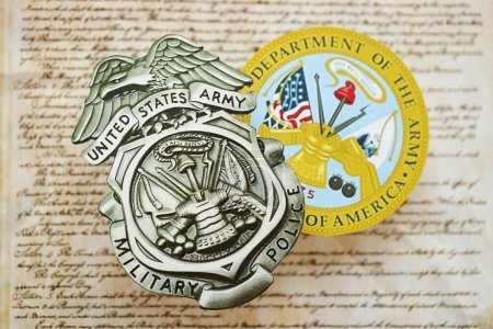 Foto de KYIV, UCRANIA - 9 de marzo de 2024 La insignia de la Policía Militar del Ejército de los Estados Unidos y el sello del Departamento de Ejército sobre la Constitución de los Estados Unidos se cierran - Imagen libre de derechos