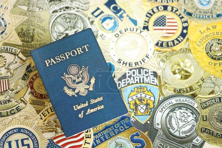 Foto de KYIV, UCRANIA - 9 DE MARZO DE 2024 US Passport se encuentra en las insignias de diferentes departamentos de policía de Estados Unidos impresos en papel de cerca - Imagen libre de derechos