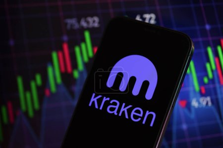 Photo for KYIV, UKRAINE - MARCH 15, 2024 Kraken logo on iPhone display screen and crypto currency value charts. Cryptocurrency exchange portal - Royalty Free Image