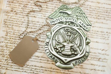 Foto de KYIV, UCRANIA - 9 de marzo de 2024 US Army Military Police badge with dogtags on United States Constitution close up - Imagen libre de derechos