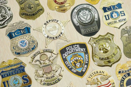 Foto de KYIV, UCRANIA - 9 de marzo de 2024 Insignias de diferentes departamentos de policía de los Estados Unidos impresas en papel de cerca - Imagen libre de derechos