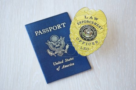 Foto de KYIV, UCRANIA - 9 de marzo de 2024 Estados Unidos La insignia de oficial de la ley y el pasaporte de Estados Unidos en la mesa de madera se cierran - Imagen libre de derechos