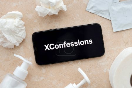 Photo for KYIV, UKRAINE - JANUARY 23, 2024 XConfessions adult content website logo on display of iPhone 12 Pro smartphone - Royalty Free Image
