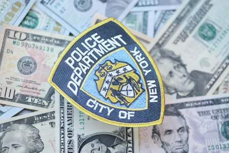 Foto de KYIV, UCRANIA - 9 de marzo de 2024 Policía de Nueva York parche en muchos billetes de dólar estadounidense de cerca - Imagen libre de derechos