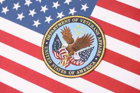 Photo for KYIV, UKRAINE - MARCH 9, 2024 US Department of Veteran Affairs seal on United States of America flag close up - Royalty Free Image