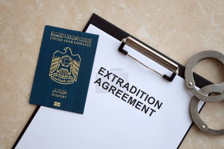 Passeport des Émirats arabes unis et accord d'extradition avec menottes sur la table close up