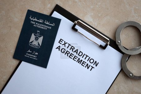 Reisepass der Palästinensischen Autonomiebehörde und Auslieferungsabkommen mit Handschellen auf dem Tisch