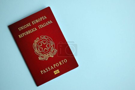 Passeport italien sur fond bleu rapproché. Concept de tourisme et de citoyenneté