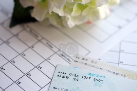 Japanese my number card specimen and notification card on calendar background close up