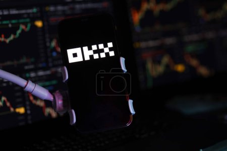 Foto de KYIV, UCRANIA - MARZO 15, 2024 logotipo OKX en la pantalla del iPhone y gráficos de valor de la moneda criptográfica. Criptomoneda portal de cambio - Imagen libre de derechos