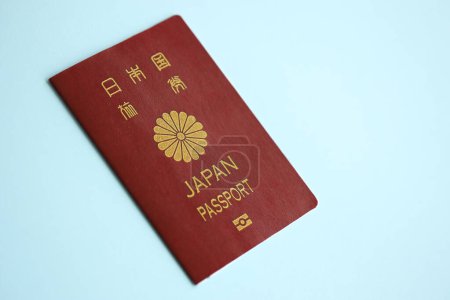 Japan passport on blue background close up. Tourism and citizenship concept
