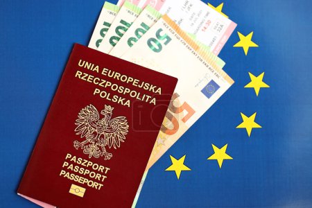 Poland passport of European Union and airlines tickets with money on blue flag background close up. Tourism and travel concept