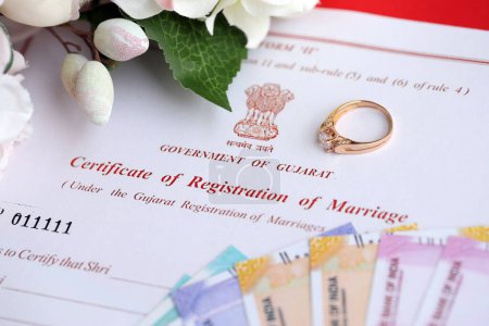 Foto de Certificado indio de registro de matrimonio documento en blanco y anillo de bodas con dinero rupia en la mesa de cerca - Imagen libre de derechos