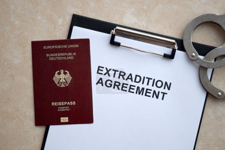 Pasaporte de Alemania y Acuerdo de Extradición con esposas en primer plano