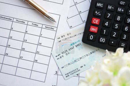 Japanisches Exemplar meiner Zahlenkarte und Benachrichtigungskarte auf Kalenderhintergrund mit Taschenrechner in Großaufnahme