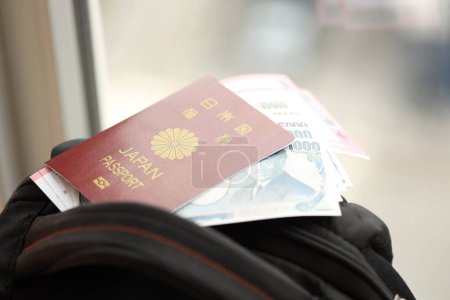 Pasaporte de Japón con billetes de yenes japoneses con billetes de avión en la mochila de cerca