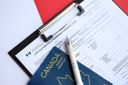 Antrag auf Daueraufenthaltskarte auf dem Tisch mit Stift und kanadischem Pass aus nächster Nähe