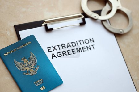 Indonesischer Pass und Auslieferungsabkommen mit Handschellen auf dem Tisch