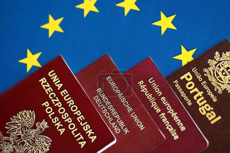 European union countries passports on blue EU flag close up. Portugal, German, French and Polish passports