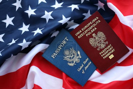 Passport of Poland with US Passport on United States of America folded flag close up