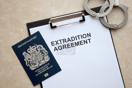 Pasaporte de Gran Bretaña y Acuerdo de Extradición con esposas en la mesa de cerca