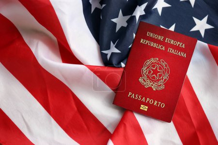 Pasaporte italiano en el fondo de la bandera nacional de los Estados Unidos de cerca. Concepto de turismo y diplomacia