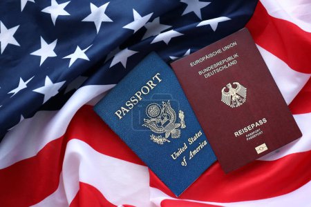 Passport of Germany with US Passport on United States of America folded flag close up