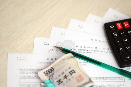 Formularios de impuestos japoneses se encuentra en la mesa con calculadora, bolígrafo y billetes de yenes japoneses rollo de cerca