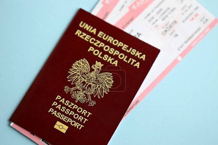 Polnischer Pass mit Flugtickets auf blauem Hintergrund in Großaufnahme. Tourismus- und Reisekonzept