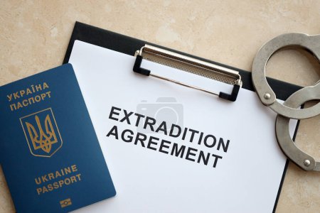 Reisepass der Ukraine und Auslieferungsabkommen mit Handschellen auf dem Tisch