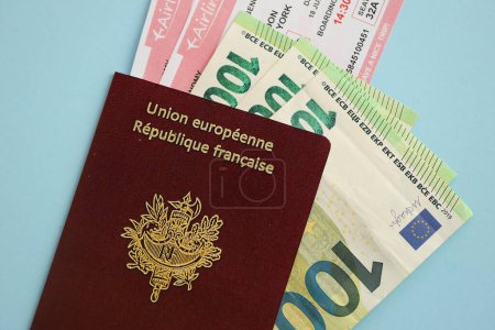 Passeport français et l'argent en euros avec des billets d'avion sur fond bleu fermer. Tourisme et concept de voyage