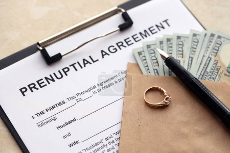 Ehevertrag und Ehering auf dem Tisch. Vorehelicher Papierkrieg in den USA hautnah