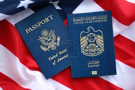 Passport of United Arab Emirates with US Passport on United States of America folded flag close up