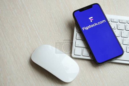 Photo for KYIV, UKRAINE - MARCH 17, 2024 Figstack logo on iPhone display screen with apple keyboard and mouse on table. Artificial Intelligence engine - Royalty Free Image