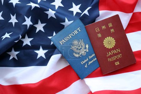Passport of Japan with US Passport on United States of America folded flag close up