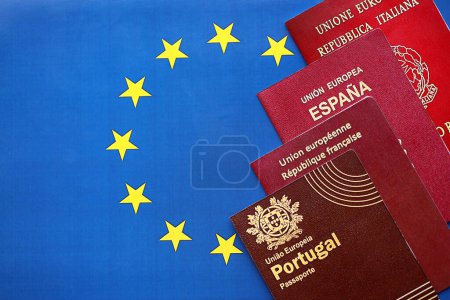 Die Pässe der EU-Länder auf blauer EU-Flagge in Großaufnahme. Portugal, spanische, französische und italienische Pässe