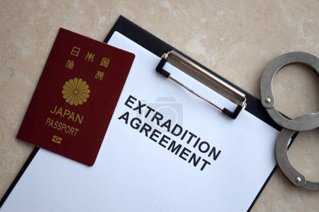 Japanischer Reisepass und Auslieferungsabkommen mit Handschellen auf dem Tisch