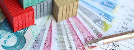 Global business container cargo ship in import export business logistic. Company shipping and logistics in Iran with rials money bills and pen close up