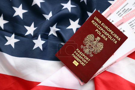 Polnischer Pass mit Flugtickets auf amerikanischer Flagge in Großaufnahme. Tourismus- und Reisekonzept