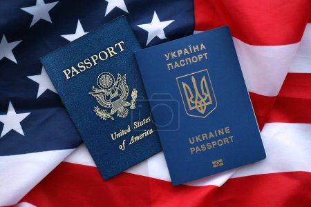 Pasaporte de Ucrania con US Passport en Estados Unidos de América bandera plegada de cerca